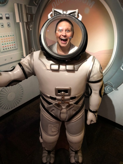 Nicole standing with her mouth open in a NASA spacesuit
