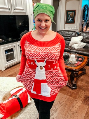 Nicole standing in the living room with her "Fa La La La Llama" Christmas sweater on